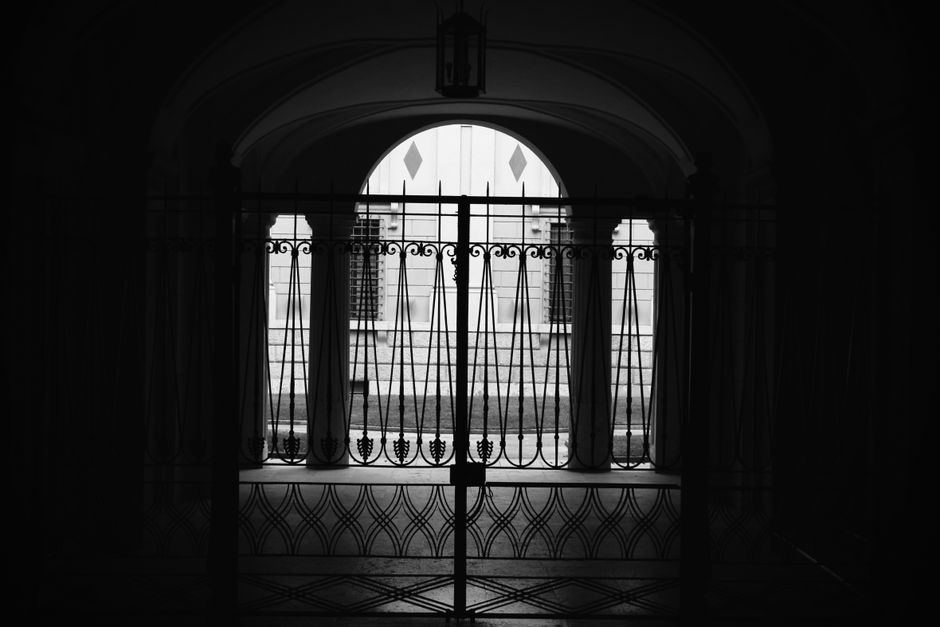 Silhouette of an iron gate with an arched top