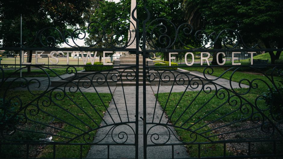 Wrought iron gate standing open on its posts