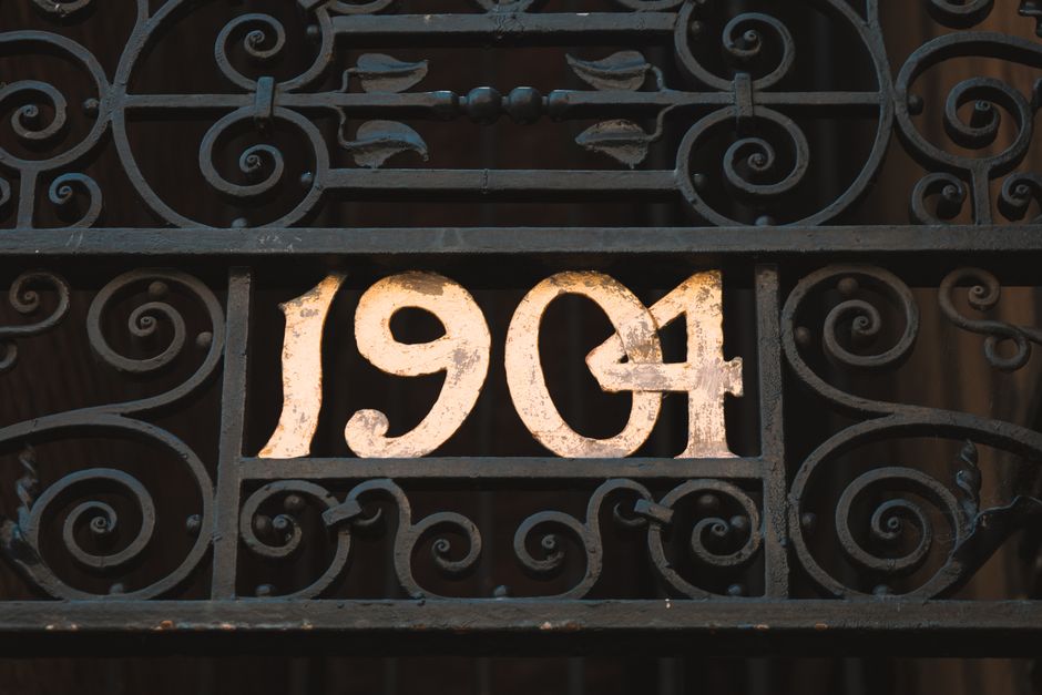Wrought iron gate with worn paint and surface rust on the bars